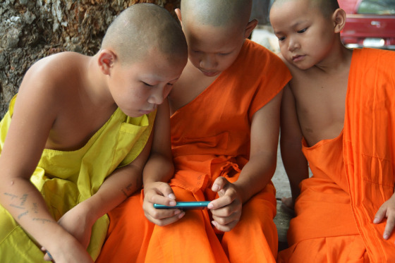 Niños budistas con videojuego